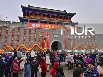 Tourists are watching a folk performance at the Ancient City scenic spot in Qingzhou, Shandong Province, China, on February 24, 2024. (