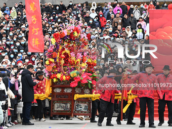 Folk artists are performing the Lifting Flower Table in Handan, Hebei Province, China, on February 24, 2024. (