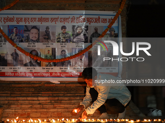 Families of deceased Nepali citizens, who enlisted as mercenaries for the Russian army, are lighting lamps during a vigil ceremony in Kathma...