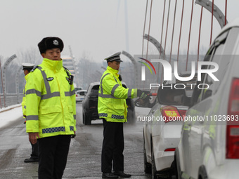 Police officers are on duty at an important intersection in Linyi, China, on February 24, 2024. They are rationally dispatching the police f...