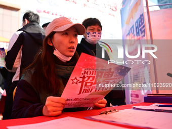 Job seekers are asking for employment information in front of a booth of an employment company at a spring job fair for SMEs in Liaocheng, C...