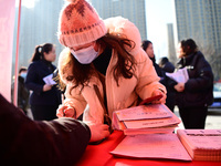 A job seeker is signing an employment agreement with an employer at a spring job fair for small and medium-sized enterprises in Liaocheng, C...