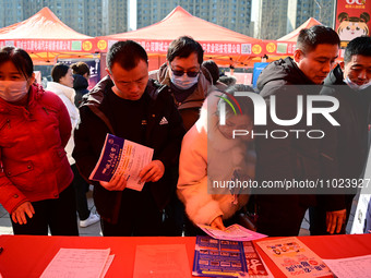 Job seekers are learning about job openings at a booth of an employment company at a spring job fair for SMEs in Liaocheng, China, on Februa...