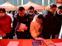 Job seekers are learning about job openings at a booth of an employment company at a spring job fair for SMEs in Liaocheng, China, on Februa...