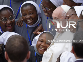 Pope Francis is posing for photos with a group of nuns at the end of his weekly general audience in the Paul VI Hall at the Vatican, on Febr...