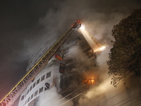 Firefighters are working to extinguish a fire in a commercial building that has killed at least 43 people in Dhaka, Bangladesh, on February...
