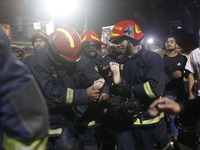 Firefighters are carrying an injured person during rescue operations following a fire in a commercial building that has killed at least 43 p...