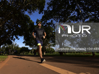 People are practicing physical activity and amateur runners are running in the Dona Sarah Kubitschek City Park in Brasilia, Brazil, on a sun...