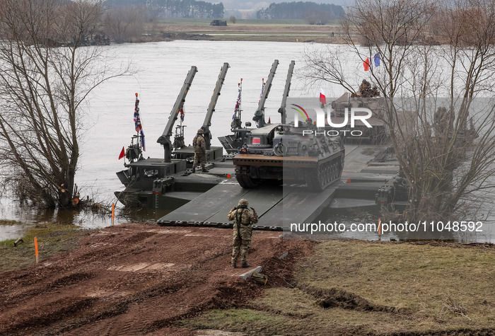 Polish and French flagged servicemen exercise ability to cross Rosomak armored vehicles through Vistula river on ferries during NATO's  Drag...