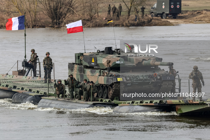Polish and French flagged servicemen exercise ability to cross Rosopak armored vehicles through Vistula river on ferries during NATO's  Drag...