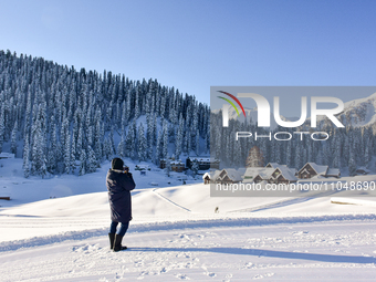 A man is clicking pictures at the Gulmarg Ski Resort in Baramulla district, Indian Administered Kashmir, on March 3, 2024. (