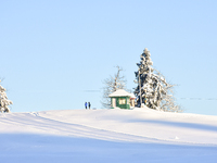 People are taking pictures on snow-covered hills following a day of snowstorms at Gulmarg Ski Resort in Baramulla district, Indian Administe...