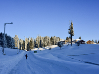 A man is walking on a snow-covered road after a day of snowstorm at the Gulmarg Ski Resort in Baramulla district, Indian Administered Kashmi...