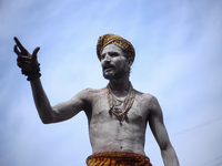 A Naga Baba, also known as a Naked Hindu saint, is gesturing while smearing ashes over his body after taking a bath on the embankments of th...