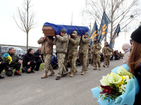 Servicemen are carrying the coffin to the Alley of Heroes while members of the public are kneeling to show their respect during the memorial...