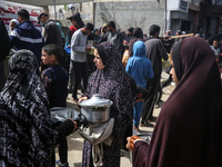 Displaced Palestinians are gathering to receive food at a donation point in Deir al-Balah, central Gaza Strip, on March 6, 2024, amid widesp...