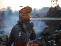 A sadhu, a Hindu holy person, is smoking marijuana from a traditional chillum on the eve of the Maha Shivaratri festival at the Pashupatinat...