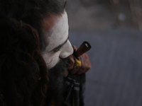 A sadhu, a Hindu holy person, is smoking marijuana from a traditional chillum on the eve of the Maha Shivaratri festival at the Pashupatinat...