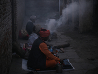 A group of Sadhus, Hindu holy people, are warming themselves with a fire on the eve of the Maha Shivaratri festival at the Pashupatinath Tem...
