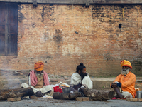 Sadhus, or Hindu holy men, are sitting beside a bonfire on the premises of Pashupatinath Temple on the eve of Maha Shivaratri in Kathmandu,...