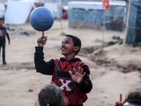 Palestinian children play near makeshift tents in Deir al-Balah, central Gaza Strip, on March 7, 2024, as battles continue between Israel an...