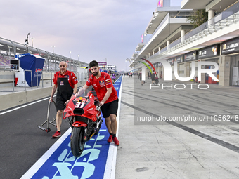 Mechanics are working on a bike in the pit lane on Day One of the Qatar MotoGP at the Lusail International Circuit in Lusail, Qatar, on Marc...