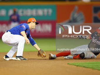 New York Mets second baseman Joey Wendle #13 is tagging out Washington Nationals' Ildemaro Vargas #14 during the fourth inning of a baseball...