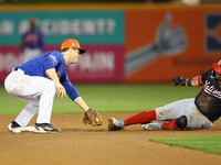 New York Mets second baseman Joey Wendle #13 is tagging out Washington Nationals' Ildemaro Vargas #14 during the fourth inning of a baseball...