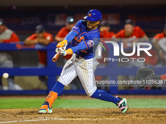 Francisco Lindor, #12 of the New York Mets, is driving in a run during the sixth inning of a baseball game against the Washington Nationals...