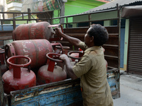 An employee is unloading cooking gas LPG cylinders from a vehicle to supply to houses in Siliguri, India, on March 8, 2024. India's Prime Mi...