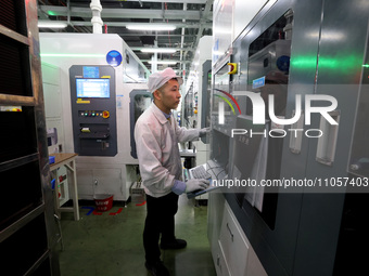 A worker is producing consumer lithium battery products at the production workshop of a new energy technology enterprise in the Dongqiao Eco...