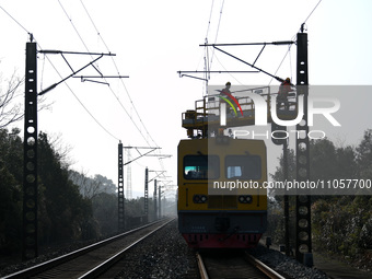 An overhead contact line worker from the Nanchang power supply section of Southern Railway is overhauling overhead contact line equipment in...
