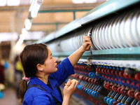 A female worker is working at a production workshop of a silk company in Chongqing, China, on March 8, 2024. (