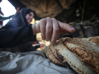 Displaced Palestinians are baking bread at a makeshift tent camp in Deir Al-Balah, Central Gaza Strip, on March 8, 2024, as battles are cont...