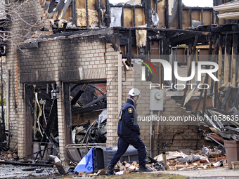 A fire investigator is walking past a home that is being torn down after it was destroyed by a reported explosion and fire in Brampton, Onta...