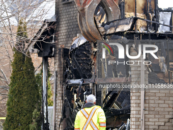 A demolition crew member is watching as a home is being torn down following its destruction by a reported explosion and fire in Brampton, On...
