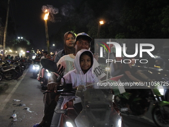 A man, accompanied by his Muslim wife and children, is welcoming the arrival of the month of Ramadan by participating in a torchlight parade...