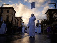 A group of women wearing masks that symbolize murdered women are walking during the International Women's Day demonstration in Granada, Spai...