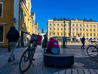 The Foodora food delivery rider is sitting on a bench in Stora Torget, Linköping, on March 8, 2024. (
