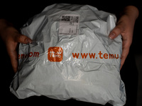 A person is holding a package from Temu. (