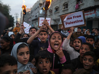 Displaced Palestinian children are raising banners during a march in Deir al-Balah in the central Gaza Strip, protesting against the ongoing...