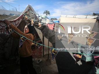 A displaced Palestinian girl is decorating her tent with Ramadan decorations in Deir al-Balah in the central Gaza Strip on March 9, 2024, am...