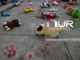 EDMONTON, CANADA - MARCH 9, 2024:
Children's toys and blood, symbolizing the victims of Ukrainian children killed during the Russian aggress...