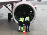 Workers are seen near a plane engine on the airport in Katowice, Poland on February 28, 2024. (