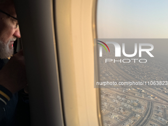 A person looks from a plane window in Abu Dhabi, United Arab Emirates on February 28, 2024. (