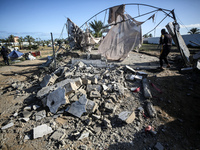 Palestinians are seen in the makeshift Al-Mawasi camp for displaced people west of Khan Yunis in the southern Gaza Strip, showing the damage...