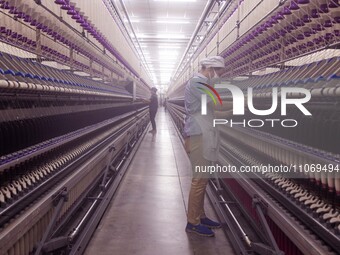 A worker is operating an intelligent production line at a textile company in Taizhou, Jiangsu Province, China, on March 12, 2024. (