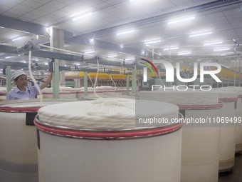 A worker is operating an intelligent production line at a textile company in Taizhou, Jiangsu Province, China, on March 12, 2024. (