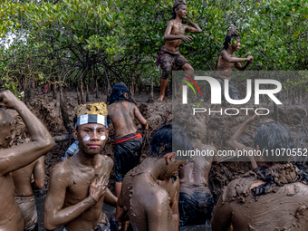 Balinese men are participating in the Mebuug Buugan rite, a mud bathing tradition following Nyepi, or the Day of Silence, in Kedongan Villag...
