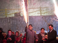 A young Iranian man is holding a firecracker while participating in the annual ''Chahar Shanbeh Soori,'' also known as the Fire Festival, in...